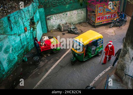 New Delhi, India. 25th Dic 2021. Un uomo vestito come Babbo Natale distribuisce caramelle/toffee a tutti nei vecchi quartieri di Delhi, India.Christmas è un festival annuale che commemora la nascita di Gesù Cristo, osservato principalmente il 25 dicembre come una celebrazione religiosa e culturale tra miliardi di persone in tutto il mondo. (Foto di Mohsin Javed/Pacific Press) Credit: Pacific Press Media Production Corp./Alamy Live News Foto Stock