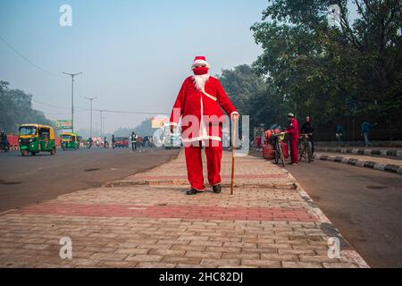 New Delhi, India. 25th Dic 2021. Un uomo vestito come Babbo Natale distribuisce caramelle/toffee a tutti nei vecchi quartieri di Delhi, India.Christmas è un festival annuale che commemora la nascita di Gesù Cristo, osservato principalmente il 25 dicembre come una celebrazione religiosa e culturale tra miliardi di persone in tutto il mondo. (Foto di Mohsin Javed/Pacific Press) Credit: Pacific Press Media Production Corp./Alamy Live News Foto Stock