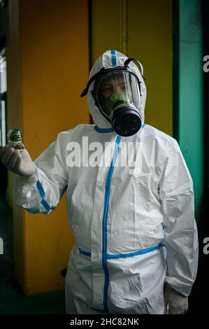 Un operatore sanitario che indossa i dispositivi di protezione individuale (PPE) si pone con una palla di neve, durante la vaccinazione. La campagna di vaccinazione anti-Covid19 nella città turistica di Tropea, sulla costa degli dei (Costa degli dei) in Calabria (Italia) prosegue anche a Natale con una giornata aperta nella Sala della palestra comunale. Con l'aumento della paura per la variante Omicron, i giorni di apertura per le festività natalizie e di Capodanno sono stati eliminati dall'Azienda sanitaria Provinciale di Vibo Valentia, con l'aiuto della protezione civile locale (protezione civile). Foto Stock