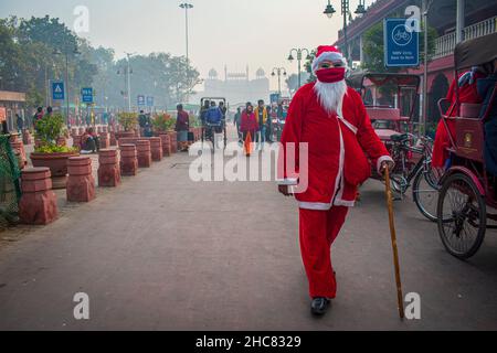 New Delhi, Delhi, India. 25th Dic 2021. Un uomo vestito come Babbo Natale distribuisce caramelle/toffee a tutti nei vecchi quartieri di Delhi, India.Christmas è un festival annuale che commemora la nascita di Gesù Cristo, osservato principalmente il 25 dicembre come una celebrazione religiosa e culturale tra miliardi di persone in tutto il mondo. (Credit Image: © Mohsin Javed/Pacific Press via ZUMA Press Wire) Foto Stock