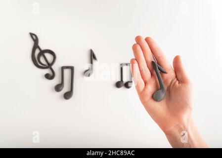 Ragazza tiene note musicali acuti clef e note sfondo. Concetto di educazione musicale Foto Stock