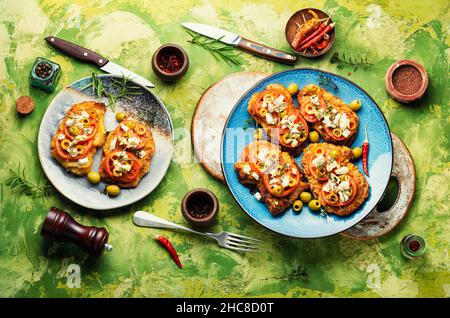Sottile strato di carne, impanato in pangrattato con formaggio, olive e pomodoro. Delizioso piatto di carne - schnitzel Foto Stock
