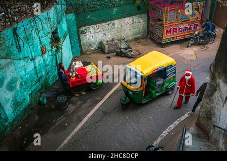 New Delhi, India. 25th Dic 2021. Un uomo vestito come Babbo Natale distribuisce caramelle/toffee a tutti nei vecchi quartieri di Delhi, India.Christmas è un festival annuale che commemora la nascita di Gesù Cristo, osservato principalmente il 25 dicembre come una celebrazione religiosa e culturale tra miliardi di persone in tutto il mondo. (Foto di Mohsin Javed/Pacific Press/Sipa USA) Credit: Sipa USA/Alamy Live News Foto Stock