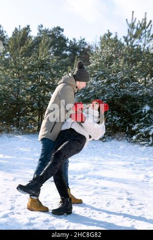 Una coppia che ama ballare nella foresta invernale. Giorno limpido e gelido. Telaio verticale. Foto Stock