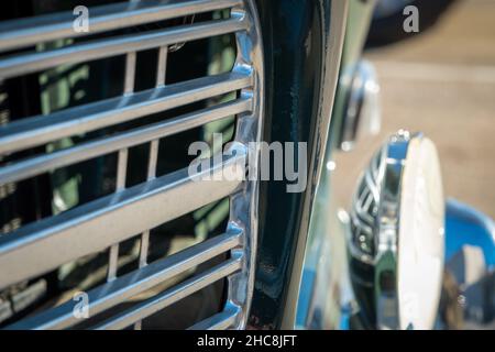 Vista macro della griglia cromata e della lampada frontale sull'automobile classica Foto Stock