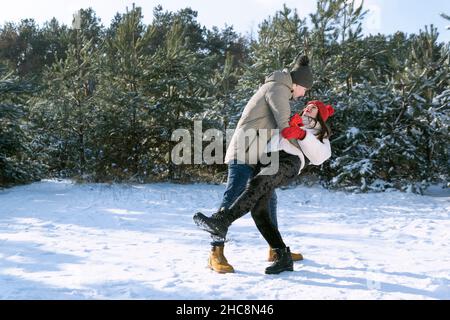 Una coppia che ama ballare nella foresta invernale. Cammina in una giornata limpida e gelida Foto Stock