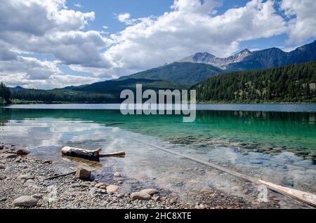 Incantevole vista su un lago tranquillo circondato da alberi e montagne Foto Stock