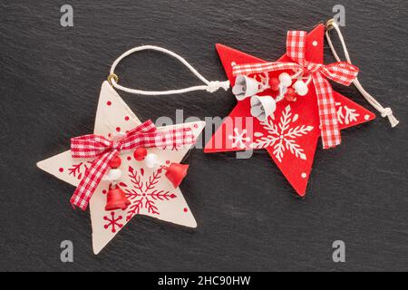 Due giocattoli di Natale in legno a forma di stella su una pietra d'ardesia, primo piano, vista dall'alto. Foto Stock