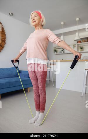 Signora anziana che fa l'allenamento di idoneità a casa Foto Stock