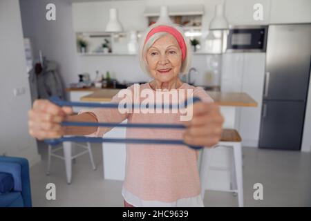 Signora anziana che fa l'allenamento di idoneità a casa Foto Stock