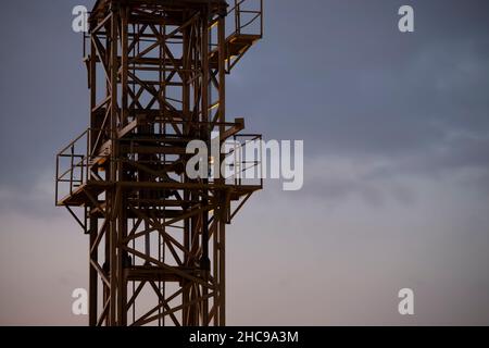 Gru da cantiere gialla fotografata contro il cielo durante il tramonto Foto Stock