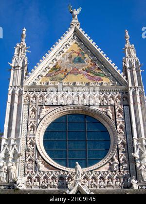 Facciata del Duomo di Siena sormontata dall'incoronazione del mosaico della Vergine Foto Stock