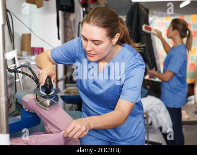 Donna stiratura abiti a secco Foto Stock