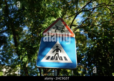 Il segno mostra il crosswalk e l'esistenza dei bambini nella zona Foto Stock