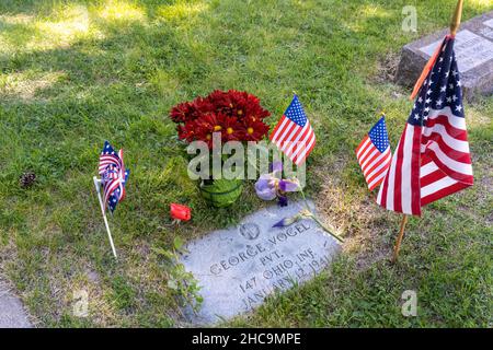 Una piccola bandiera americana e fiori decorano la tomba di un veterano della Guerra civile americana durante la festa del Memorial Day. Il Memorial Day è un americano Foto Stock