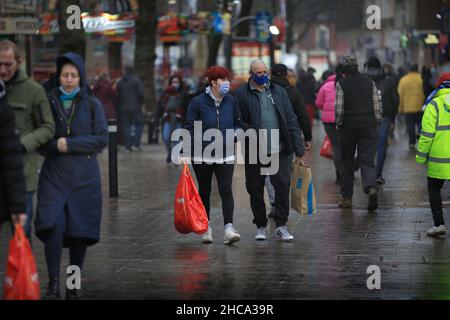 Peterborough, Regno Unito. 26th Dic 2021. I clienti che indossano maschere facciali come misura protettiva contro la diffusione di coronavirus trasportano i sacchetti di shopping che contengono le merci durante il giorno di boxe sales.The strade sono estremamente tranquille il giorno di boxe, con pochissimi acquirenti come le vendite iniziano nei negozi nel centro di Peterborough. (Foto di Martin Pope/SOPA Images/Sipa USA) Credit: Sipa USA/Alamy Live News Foto Stock