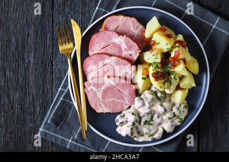 Judd Mat Gaardebounen, colletto di maiale affumicato con fagioli larghi sbolliti cotti con salsa cremosa e patate bollite su un piatto, piatto nazionale di Luxem Foto Stock