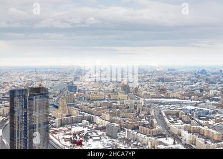 Le aree urbane e le autostrade sono coperte di neve. Vita quotidiana della città, vista dall'alto di Mosca in una giornata invernale, fotografia aerea Foto Stock