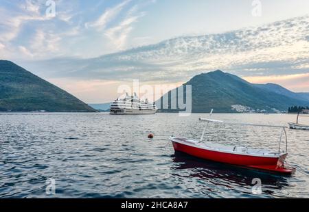 In estate, le barche galleggiano sulle acque calme di questa cittadina turistica costiera non lontano da Cattaro. Foto Stock