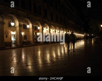 Luci che si riflettono sul marciapiede di notte al Liston; città di Corfù, Grecia Foto Stock
