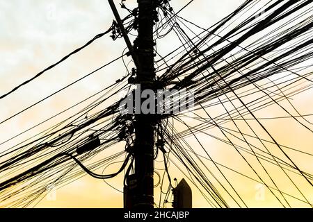 Cavi elettrici e telefonici e fili su un palo nelle strade della metropoli. Salvador, Bahia, Brasile. Foto Stock