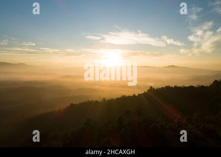 Incredibile paesaggio natura paesaggio natura vista aerea vista drone camera Fotografia di nebbia o nebbia che scorre sul picco di montagna in l'alba del mattino o su Foto Stock