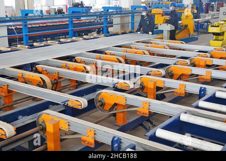 YANTAI, CINA - 27 DICEMBRE 2021 - Un lavoratore produce materiali leggeri presso il Centro di innovazione Automotive Lightweight di Yantai, Shandong Provin Foto Stock