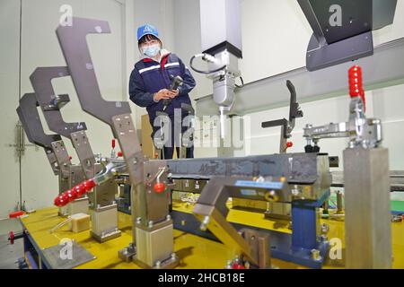 YANTAI, CINA - 27 DICEMBRE 2021 - i tecnici eseguono il debug di uno strumento di misura coordinato presso il Centro innovazione Automotive Lightweight di Yantai High Foto Stock