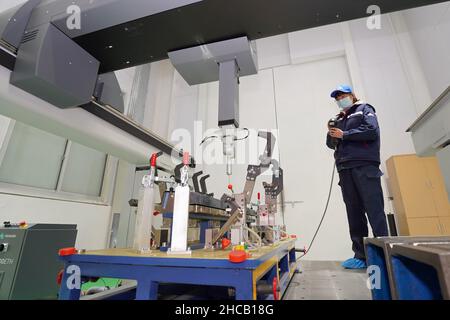 YANTAI, CINA - 27 DICEMBRE 2021 - i tecnici eseguono il debug di uno strumento di misura coordinato presso il Centro innovazione Automotive Lightweight di Yantai High Foto Stock