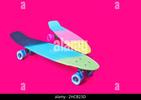 Due skateboard in plastica Rainbow Penny su sfondo cremisi Foto Stock