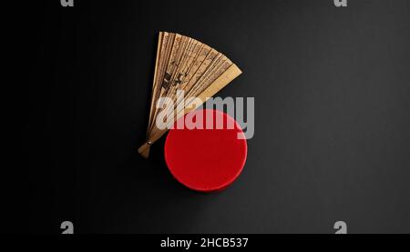 Ventilatore in legno orientale e scatola blu su sfondo scuro Foto Stock