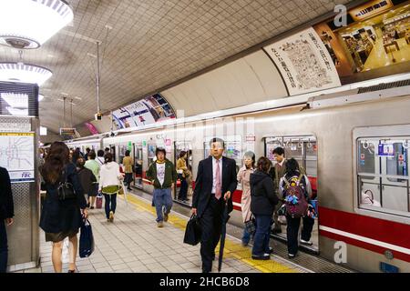 Passeggeri, compreso un salarista, scendere da un treno sulla metropolitana Kobe, metro, sulla linea Seishin-Yamate anche nota come linea verde. Foto Stock