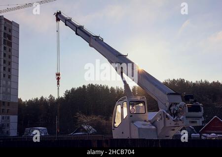 Autogru in cantiere. Attrezzature per il sollevamento di carichi pesanti in cantiere Foto Stock
