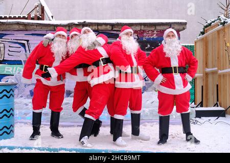 Minsk, Bielorussia, 25 dicembre 2021: Fiera del nuovo anno 5 Santaclaus guardare nella cornice. Foto Stock