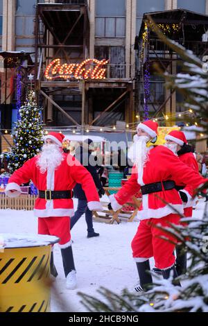 Minsk, Bielorussia, 25 dicembre 2021: Tre Babbo Natale alla fiera di Capodanno divertire le persone. Foto Stock