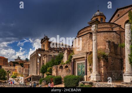 Cielo tempestoso sopra gli antichi templi del Foro Romano nella città di Roma, Italia. Tempio di Romolo e Tempio di Antonino e Faustina e San Lorenzo in Foto Stock