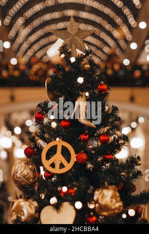 Decorazione di Natale con hippie icona figurine e scarpe alte del tallone femminile appesi su un albero di Natale. Decorazioni creative Foto Stock