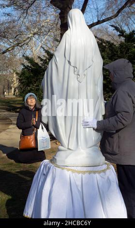 Dopo un servizio di preghiera in un parco, devoti cattolici romani pregano per una statua della Vergine Maria. Nel sito delle apparizioni di Veronica Lueken a NYC. Foto Stock