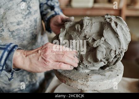 Primo piano di ceramica maschile che lavora con argilla, che forma di scultura su ruota in ceramica Foto Stock