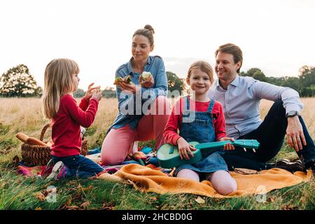 Famiglia felice godersi un picnic al parco Foto Stock