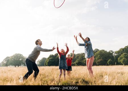 Genitori allegri che giocano con le figlie nel parco Foto Stock