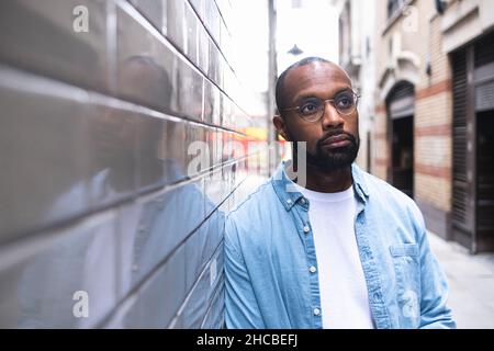 Considerato l uomo appoggiato sulla parete Foto Stock