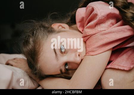 Ragazza con occhi grigi in camera da letto a casa Foto Stock