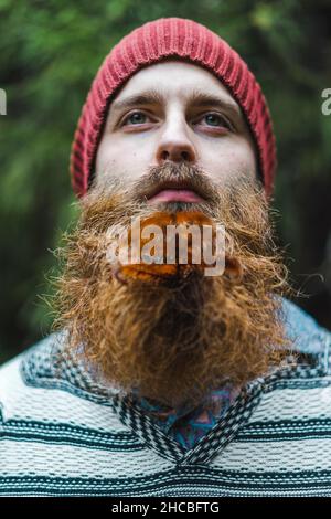 Giovane uomo portico con cappello a maglia in foresta Foto Stock