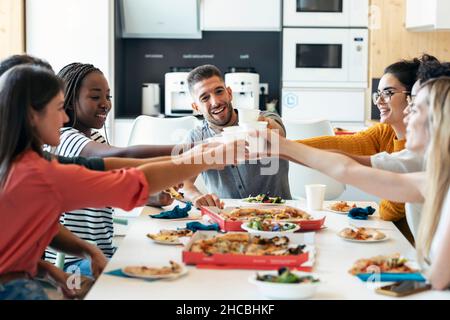 Sorridenti colleghi multirazziali che tostano bevande alla caffetteria durante la pausa pranzo Foto Stock