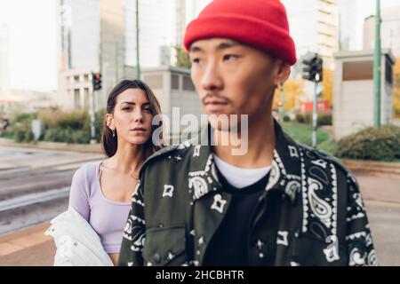 Giovane donna in piedi dietro l'uomo sul sentiero Foto Stock