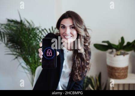 Donna d'affari che mostra smartphone con logo lucchetto Foto Stock