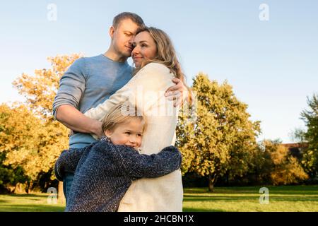 Donna che gira la palla sul dito con il figlio in background al parco Foto Stock