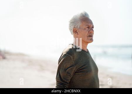 Uomo d'affari meditando capovolto legato in su con la corda sull'albero al parco Foto Stock