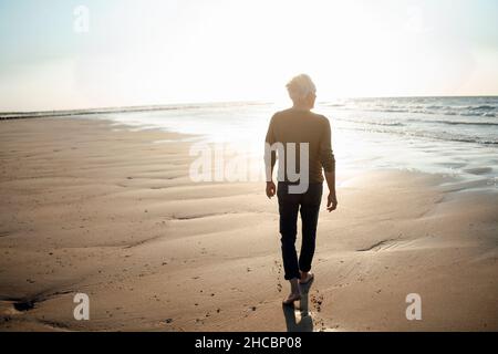 Giovane donna con capelli in spiaggia Foto Stock